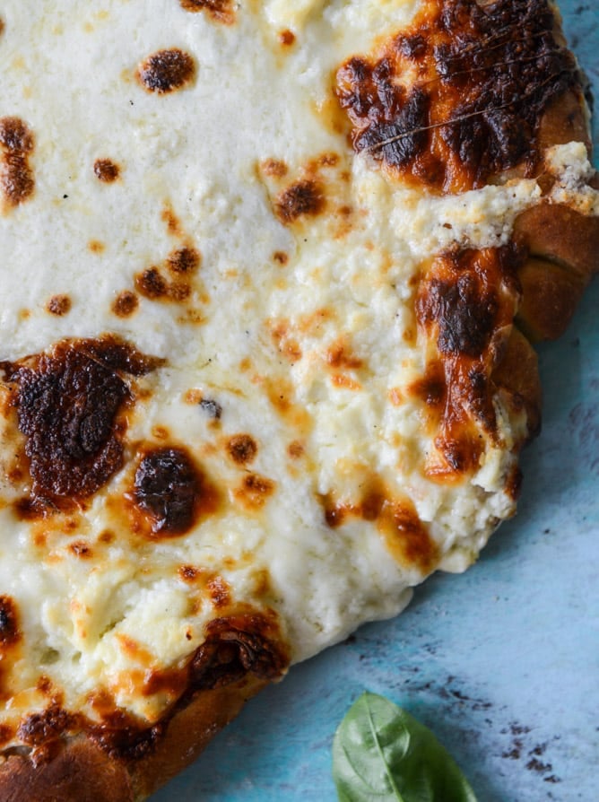 white pizza with garlic sauce and garden herbs I howsweeteats.com