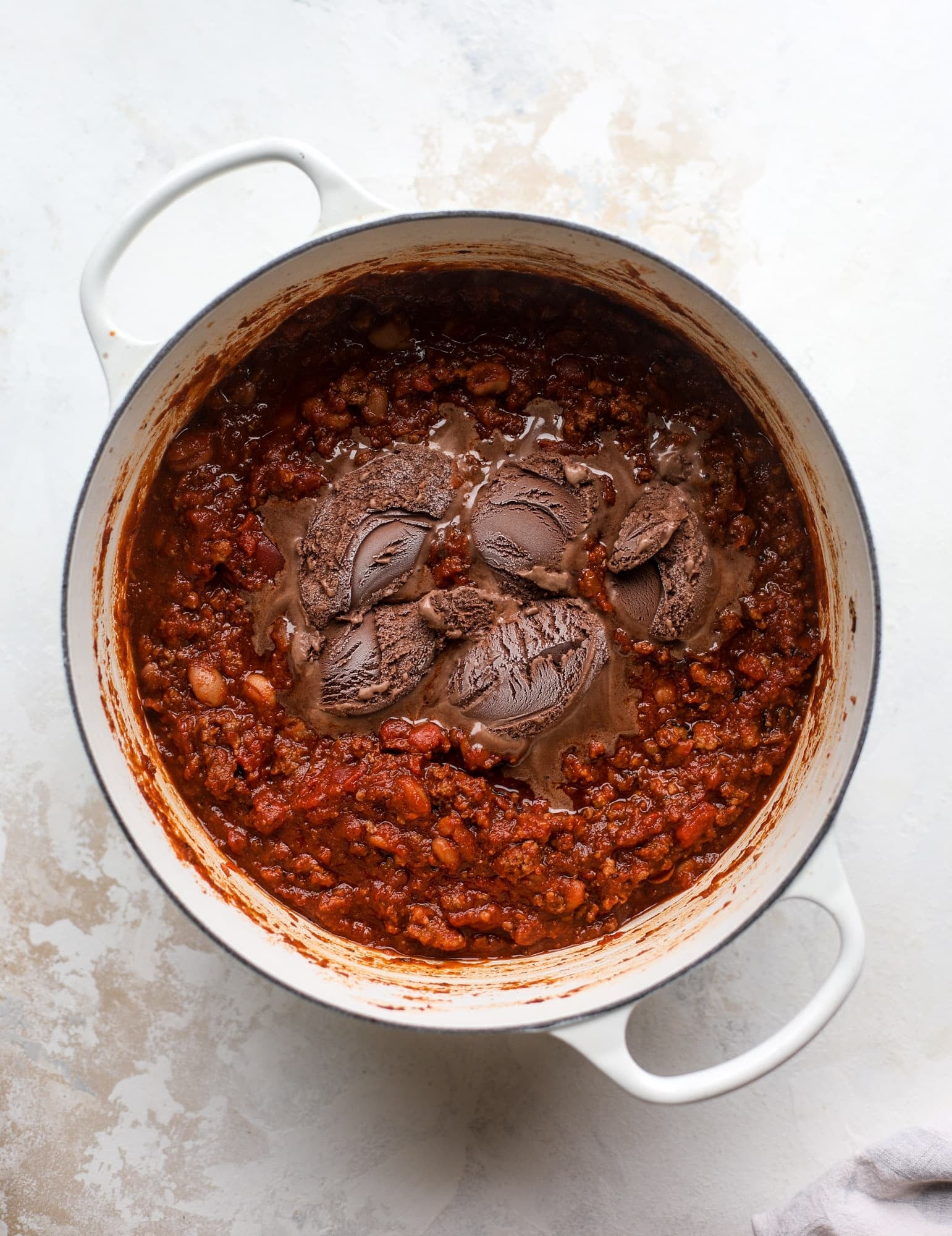 This fire and ice chili has a secret ingredient that makes it rich, velvety and insanely delicious. Dark chocolate ice cream is stirred in before serving and adds a crazy depth of flavor while bringing so much richness to your favorite bowl. You have to try it! I howsweeteats.com #chili #recipe #ice #cream #chili #bar