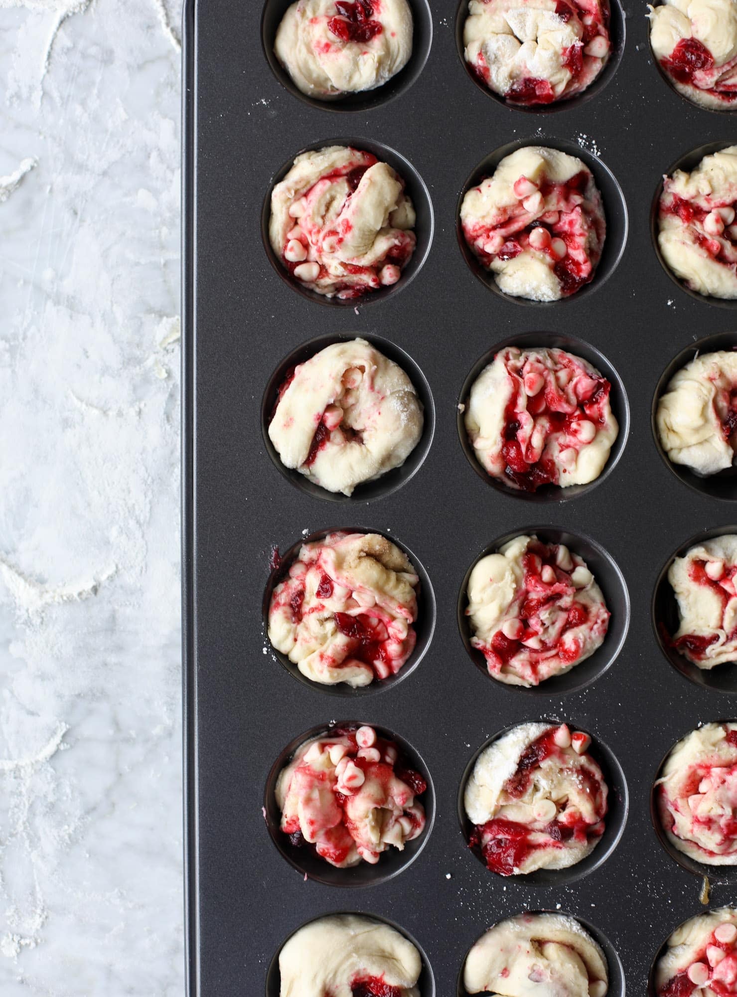 These white chocolate cranberry sticky buns are what holiday dreams are made of! Made in a muffin tin with fresh cranberries and creamy white chocolate, they are drizzled with cranberry caramel too! Dreamy! I howsweeteats.com #sticky #buns
