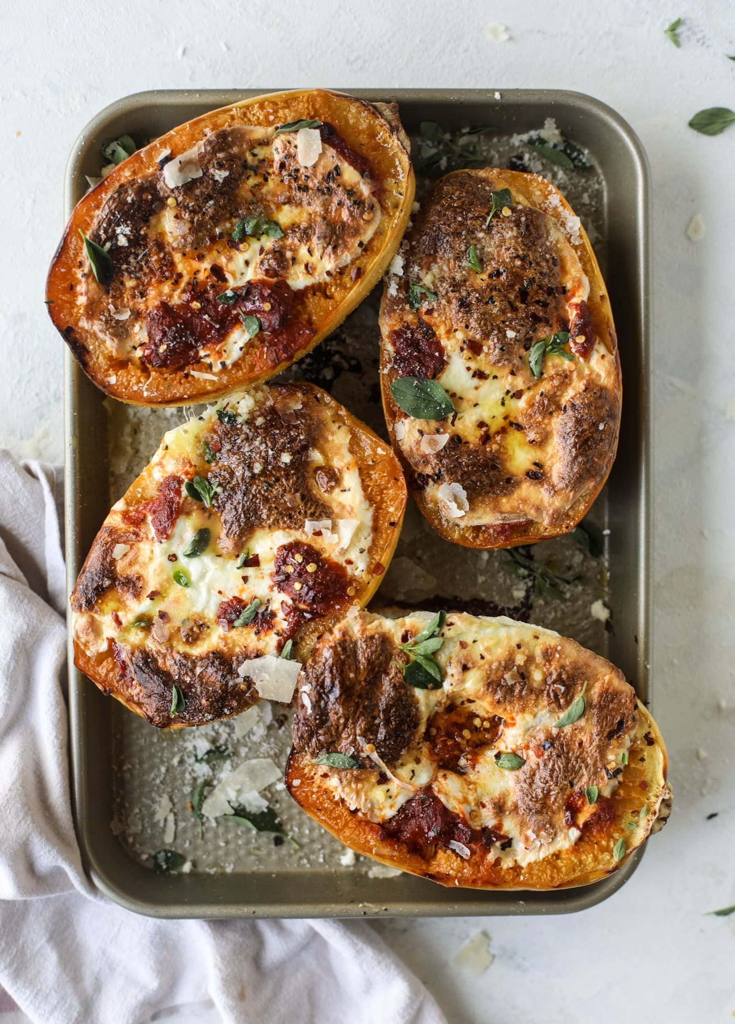 Spaghetti squash parmesan is a delicious weeknight meal! Topped with marinara or bolognese, melty cheese and fresh herbs, it's easy and delicious! I howsweeteats.com #spaghettisquash #parmesan