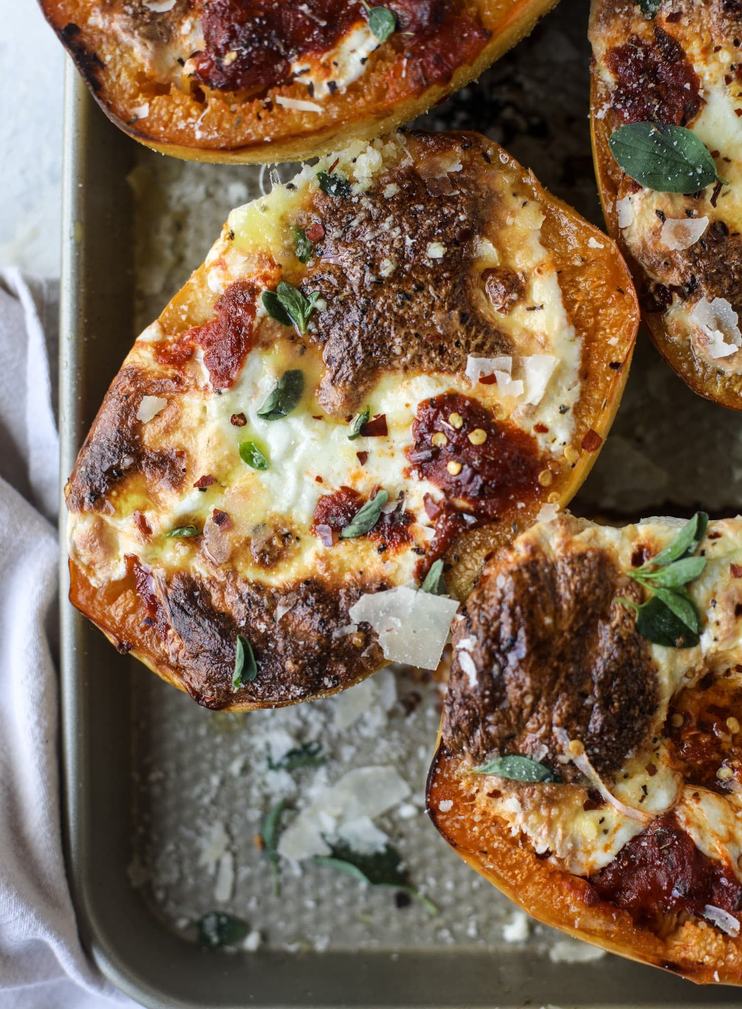 Spaghetti squash parmesan is a delicious weeknight meal! Topped with marinara or bolognese, melty cheese and fresh herbs, it's easy and delicious! I howsweeteats.com #spaghettisquash #parmesan
