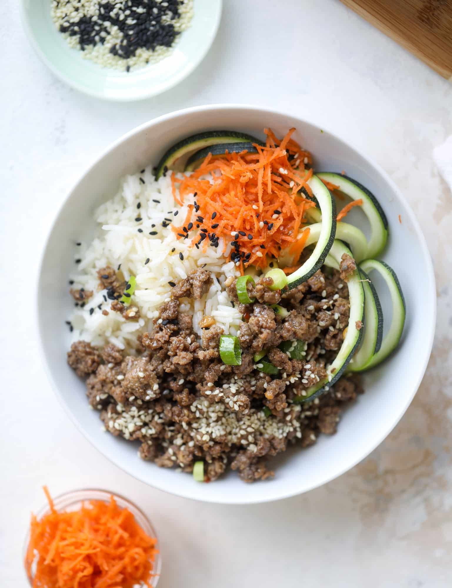 These korean beef bowls are so packed full of flavor that you won't want to eat anything else! Serve the beef with zucchini noodles, grated carrot and jasmine rice for a satisfying, flavor-packed bowl that comes together easily and quick! I howsweeteats.com #korean #beef