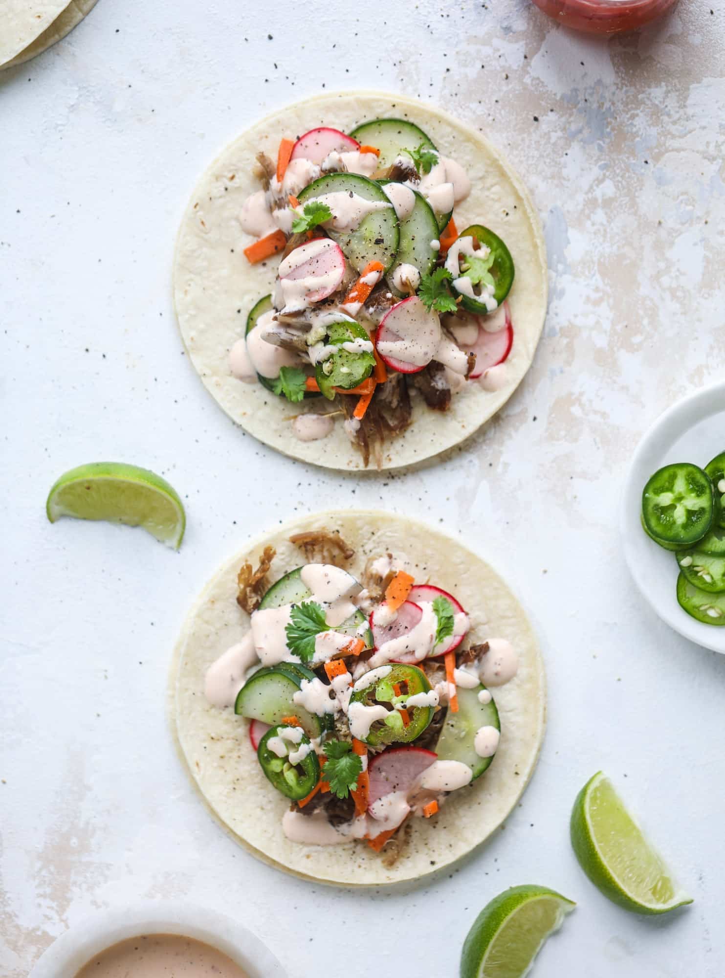 These bahn mi tacos are the perfect twist on the classic sandwich! Juicy pulled pork, pickled veggies, a tangy crema and loads of flavor. Bahn mi tacos are a delish weeknight meal or also work great if you have pork leftovers! I howsweeteats.com #bahn #mi #tacos #pork #dinner