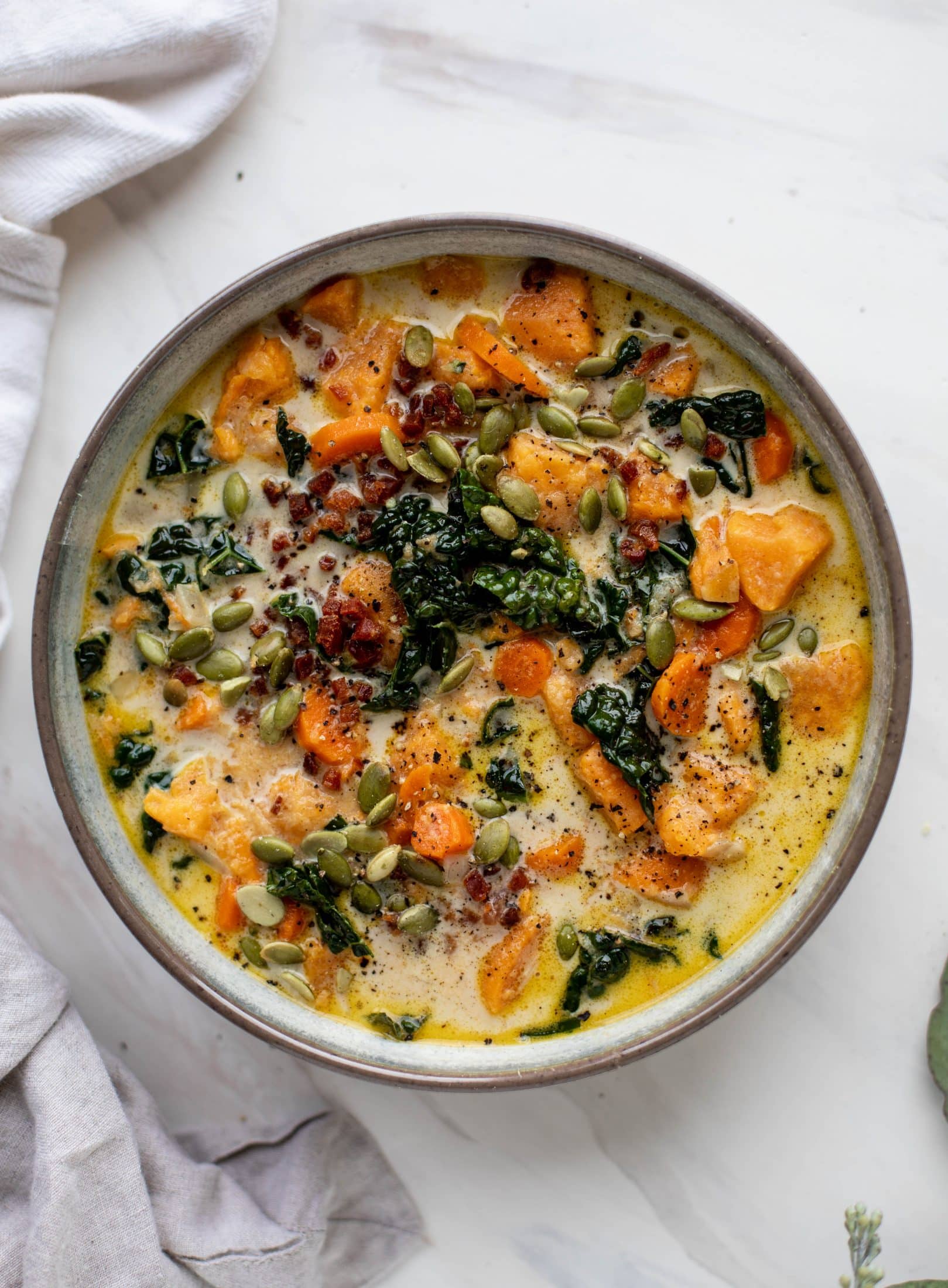 This sweet potato chowder is a hug in a bowl! Made with lots of greens and crunchy pancetta and pepitas for topping, it's a perfect weeknight meal.